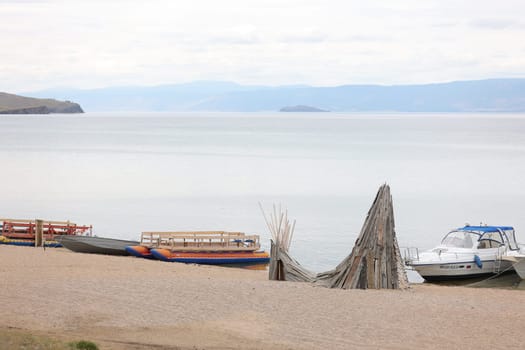 Baikal pier for boats and catamarans on Olkhon Island against the background of mountains and Lake Baikal