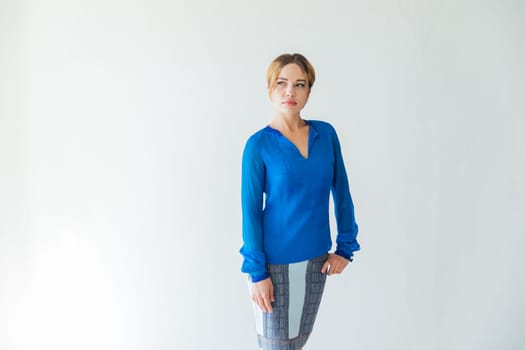 Beautiful fashionable young woman in blue on autumn city street