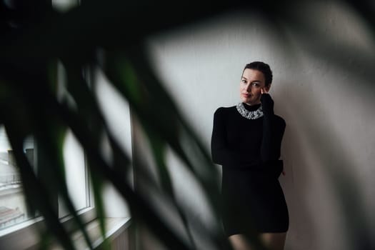 Portrait of beautiful fashionable woman with short haircut in black evening dress