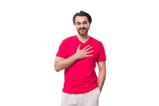 young kind european man dressed in a red corporate t-shirt and white trousers.