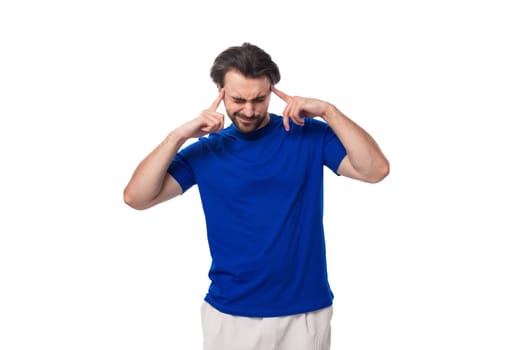 young handsome european man with black hair and beard dressed in a blue t-shirt.