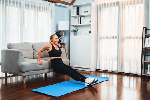 Athletic and active senior woman using furniture for effective targeting muscle with push up at home exercise as concept of healthy fit body lifestyle after retirement. Clout