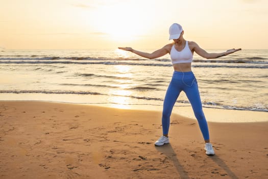 a sporty girl at dawn doing exercises on the seashore in sportswear, there is a place for an inscription. High quality photo