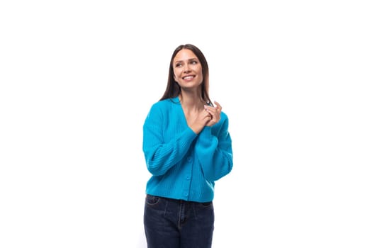 young well-groomed brunette woman dressed in a blue cardigan on a white background with copy space.
