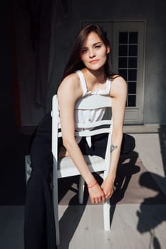 Portrait of a young slender woman sitting on a chair