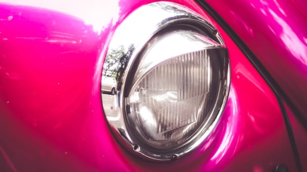 Close-up of headlights of pink  vintage retro beautiful vehicle car