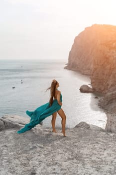 Woman sea trevel green dress. Side view a happy woman with long hair in a long mint dress posing on a beach with calm sea bokeh lights on sunny day. Girl on the nature on blue sky background