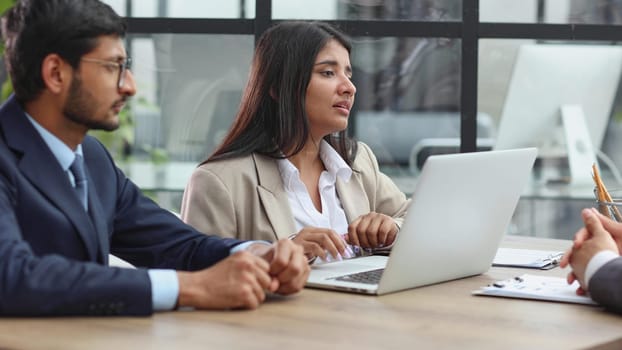 Human resources team sitting in a row at table in office