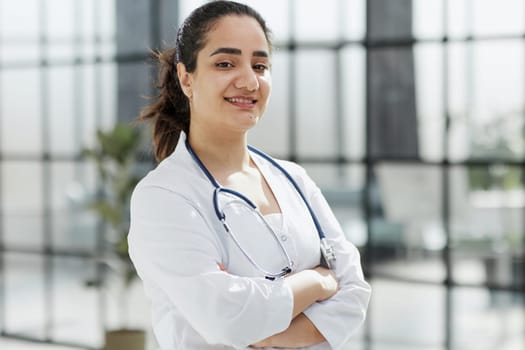 Dentist woman standing with crossed arms. Confident dentist standing in a hospital corridor in a white coat. Generative AI