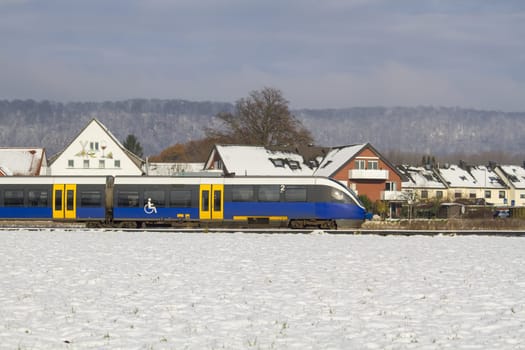 German regional train against the backdrop of houses and forest. High quality photo