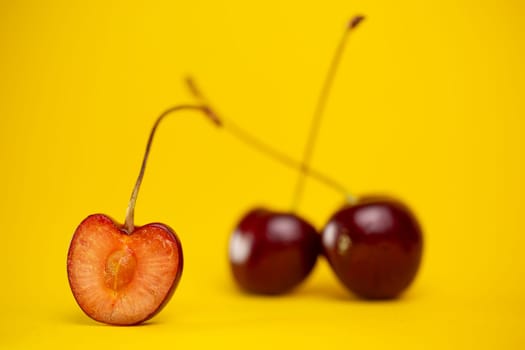 ripe fresh cherry berries on a yellow background.