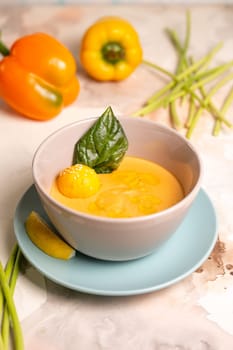 pumpkin cream soup with a slice of lemon in a plate on the table.