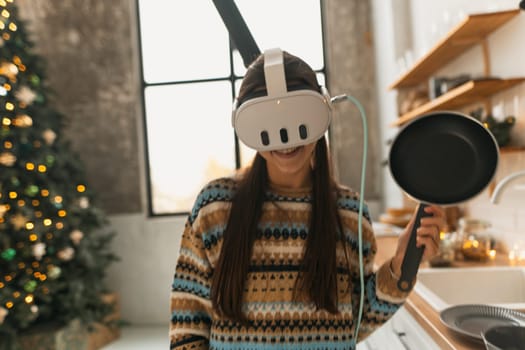 The young and beautiful woman is cooking in the kitchen with the aid of a virtual reality headset. High quality photo