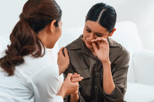 Sad PTSD woman patient in uttermost therapy for mental health with psychologist, depression or grief after life failure. Frustrated trauma young woman talking to a psychologist about emotion in clinic