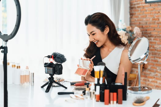 Woman influencer shoot live streaming vlog video review makeup uttermost social media or blog. Happy young girl with cosmetics studio lighting for marketing recording session broadcasting online.