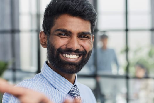 male investor beard looking at camera and smiling in modern office