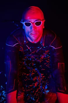 real triathlete swimmer having a break during hard training at lake on dark night neon gel color lights