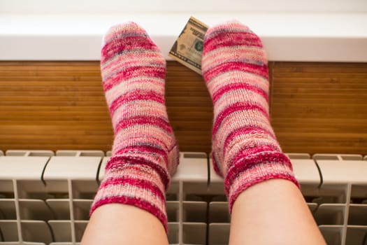 Feet in warm winter socks warm up on the radiator on cold winter days.