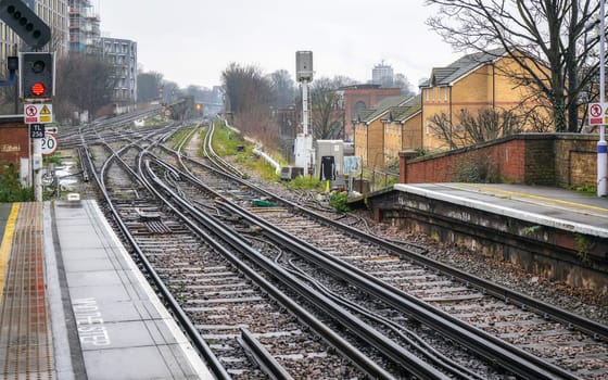 London, United Kingdom - February 01, 2019: Many railway tracks and crossings at Lewisham station on rainy day. Trains are used widely for public transport (along with Tube and Buses) in UK capital