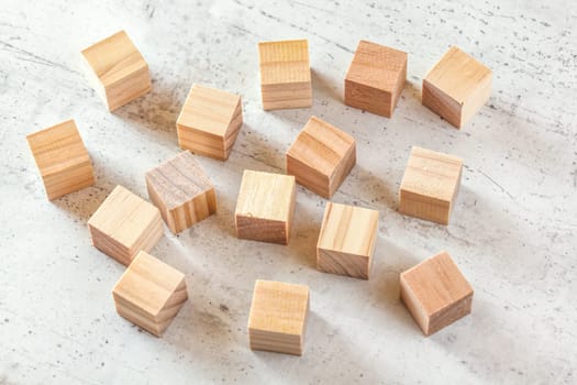 15 wooden playing cubes on white board.