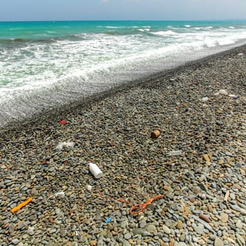 Mostly plastic rubbish on rough pebbles beach. Ocean and sea littering concept