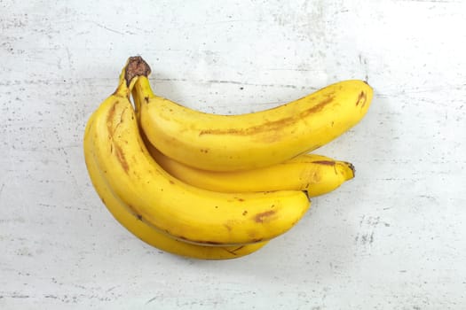 Table top view, bunch of ripe bananas on white working board.