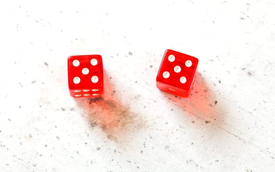 Two red craps dices showing Hard Ten (double number five) overhead shot on white board