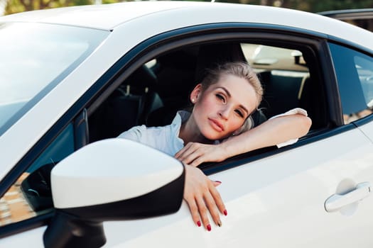 Beautiful blonde driver behind the wheel of a sports car