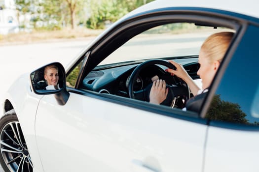 Beautiful blonde driver behind the wheel of a sports car