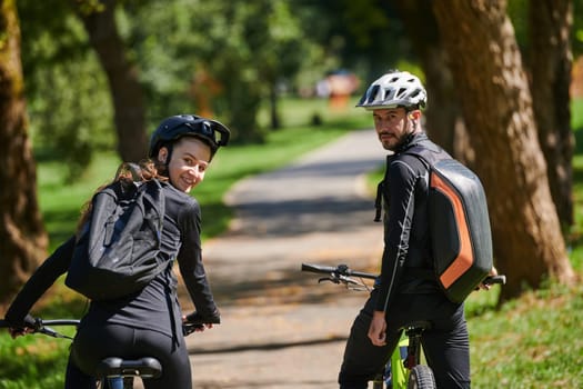 A blissful couple, adorned in professional cycling gear, enjoys a romantic bicycle ride through a park, surrounded by modern natural attractions, radiating love and happiness.