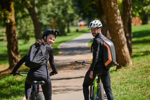 A blissful couple, adorned in professional cycling gear, enjoys a romantic bicycle ride through a park, surrounded by modern natural attractions, radiating love and happiness.