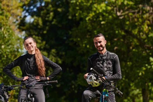 A blissful couple, adorned in professional cycling gear, enjoys a romantic bicycle ride through a park, surrounded by modern natural attractions, radiating love and happiness.