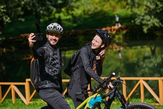 A modern couple captures the joy of their bike ride in the park through a trendy selfie, blending technology and outdoor adventure to immortalize a moment of happiness and togetherness.