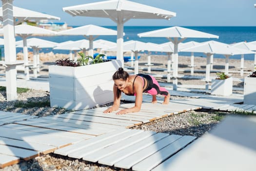 Woman yoga asana body flexibility on beach by the sea