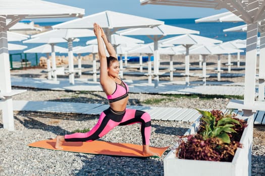 Woman yoga asana body flexibility on beach by the sea