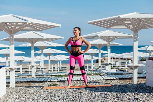 woman yoga asana fitness flexibility of body on the beach by the sea