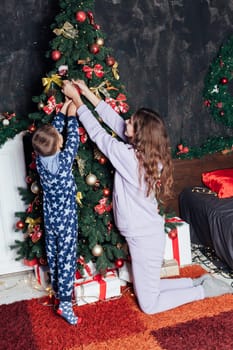 Mom and son decorate Christmas tree New Year decor