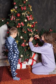 Mom and son decorate Christmas tree New Year decor