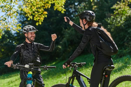 A sweet couple, adorned in cycling gear, rides their bicycles, their hands interlocked in a romantic embrace, capturing the essence of love, adventure, and joy on a sunlit path.