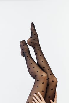 slender women's legs in black tights on a white background