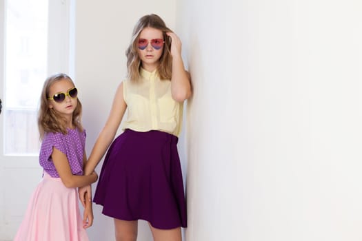 two girls in glasses from the Sun in a white room 1