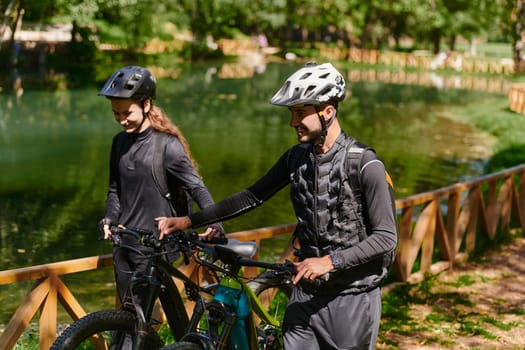 A blissful couple, adorned in professional cycling gear, enjoys a romantic bicycle ride through a park, surrounded by modern natural attractions, radiating love and happiness.