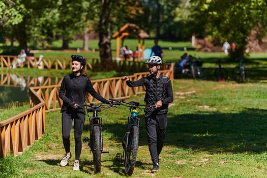 A blissful couple, adorned in professional cycling gear, enjoys a romantic bicycle ride through a park, surrounded by modern natural attractions, radiating love and happiness.