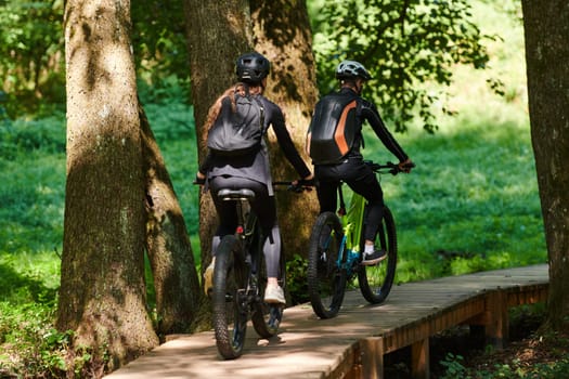 A blissful couple, adorned in professional cycling gear, enjoys a romantic bicycle ride through a park, surrounded by modern natural attractions, radiating love and happiness.