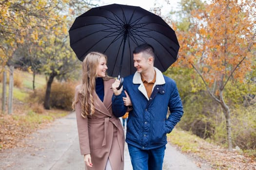 a guy with a girl go under umbrella rain good mood