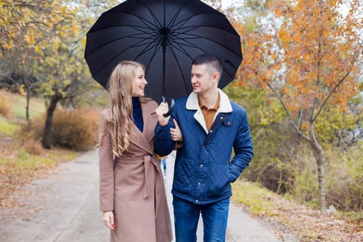 a guy with a girl go under umbrella rain good mood