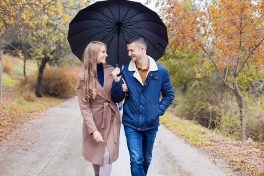 a guy with a girl go under umbrella rain good mood