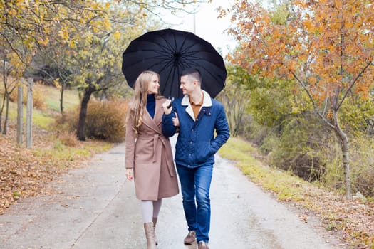 a guy with a girl go under umbrella rain good mood