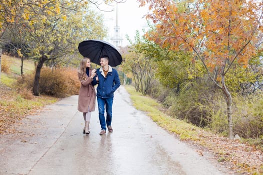 a guy with a girl go under umbrella rain good mood