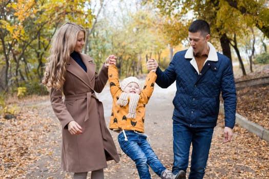 a family with a young son walk in the Park in autumn 1